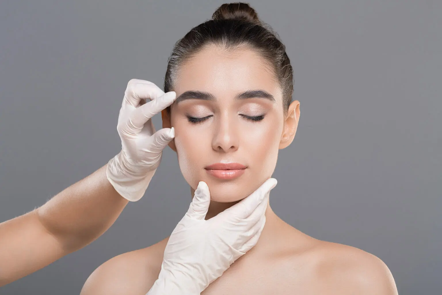 Rhinoplasty surgeon assessing patient